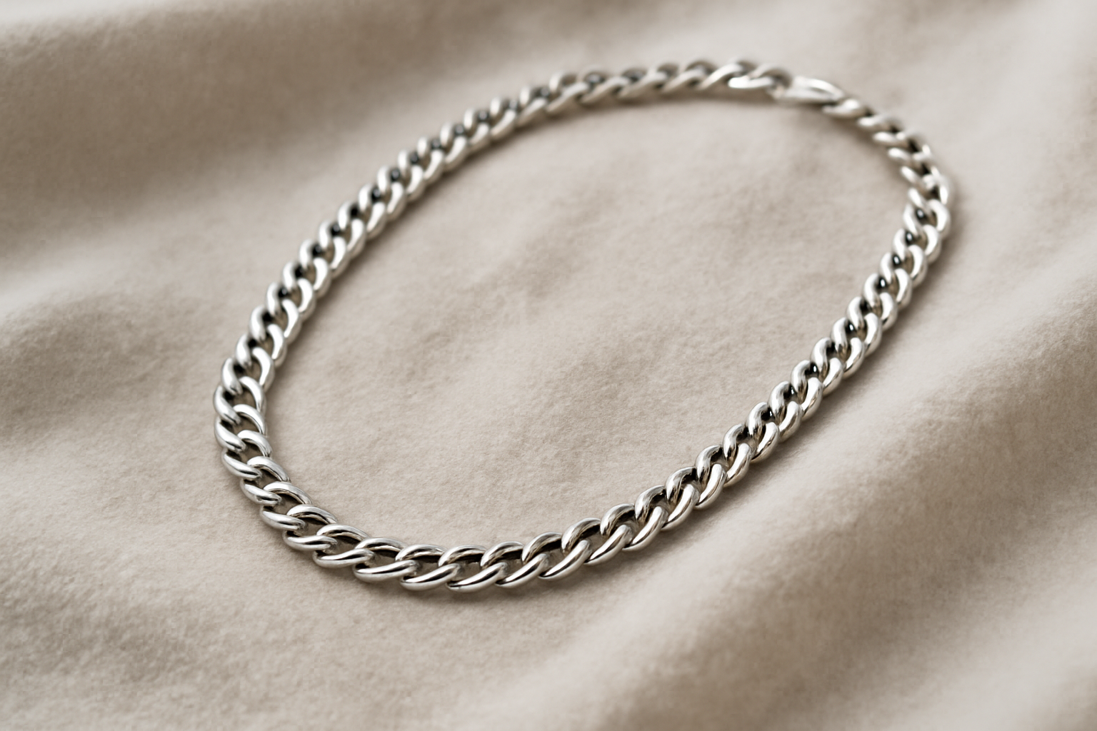 collier en argent posé sur tissu doux