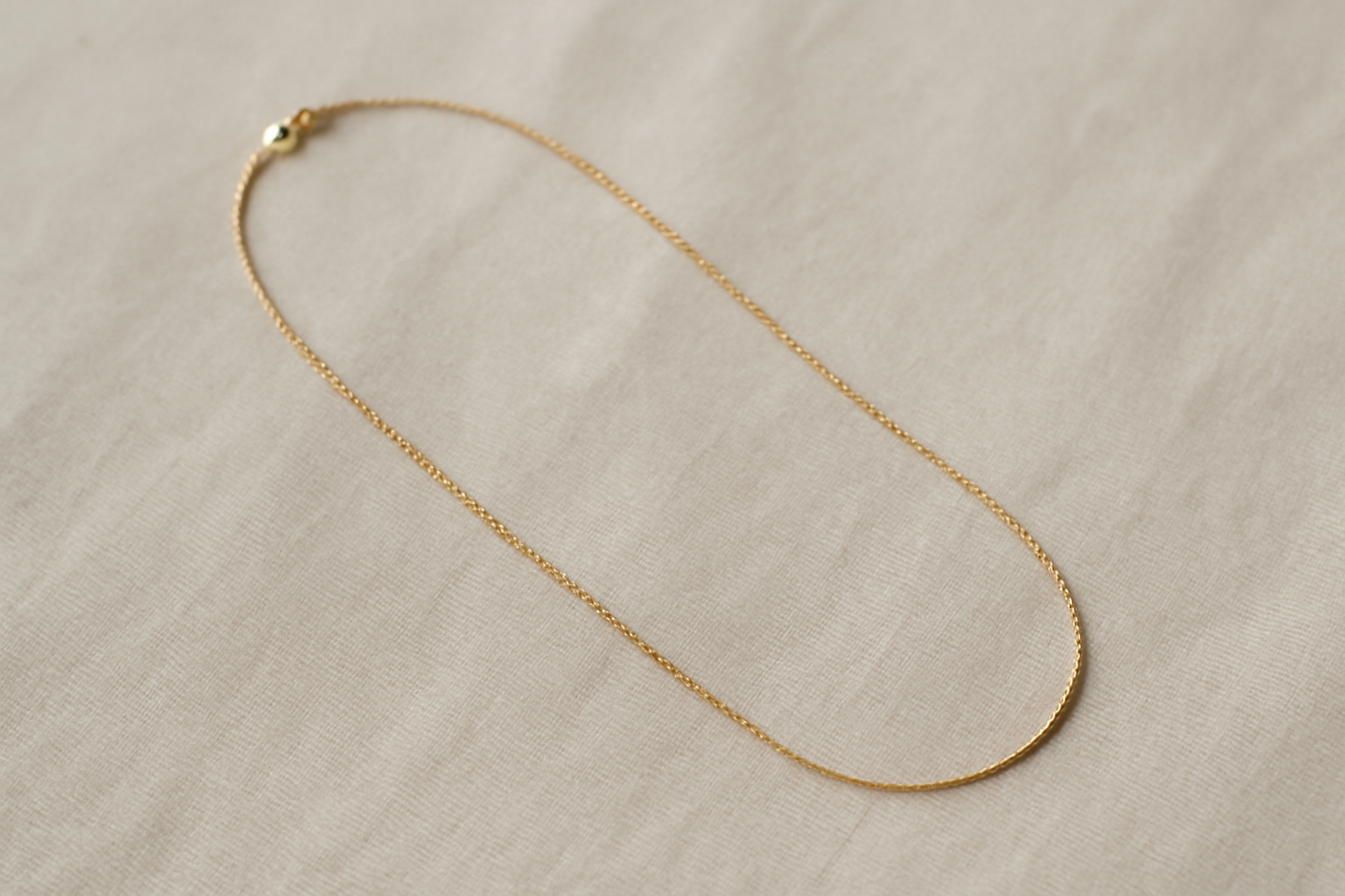 collier fin posé sur tissu neutre