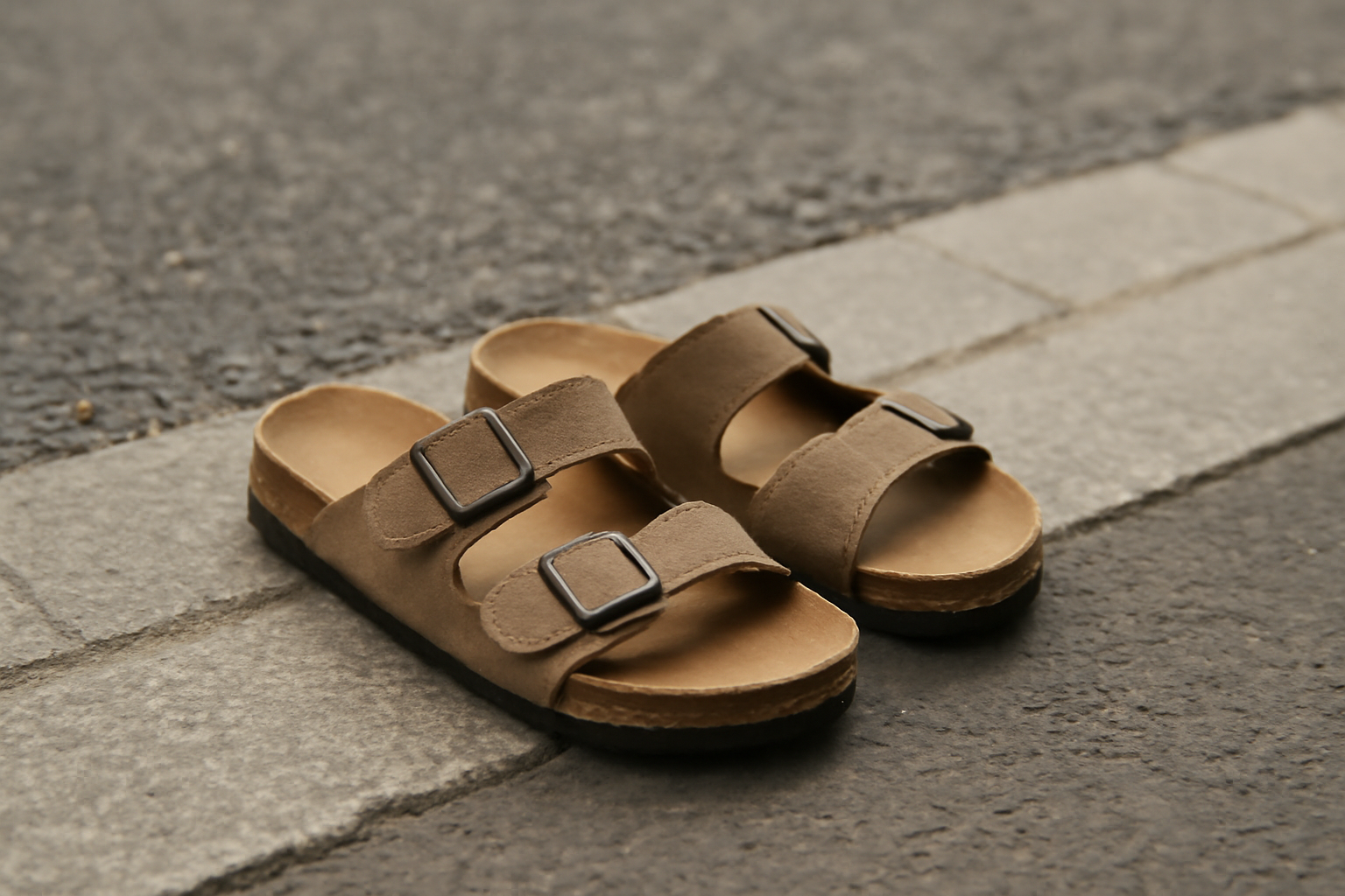 paire de sandales posée sur bord de rue
