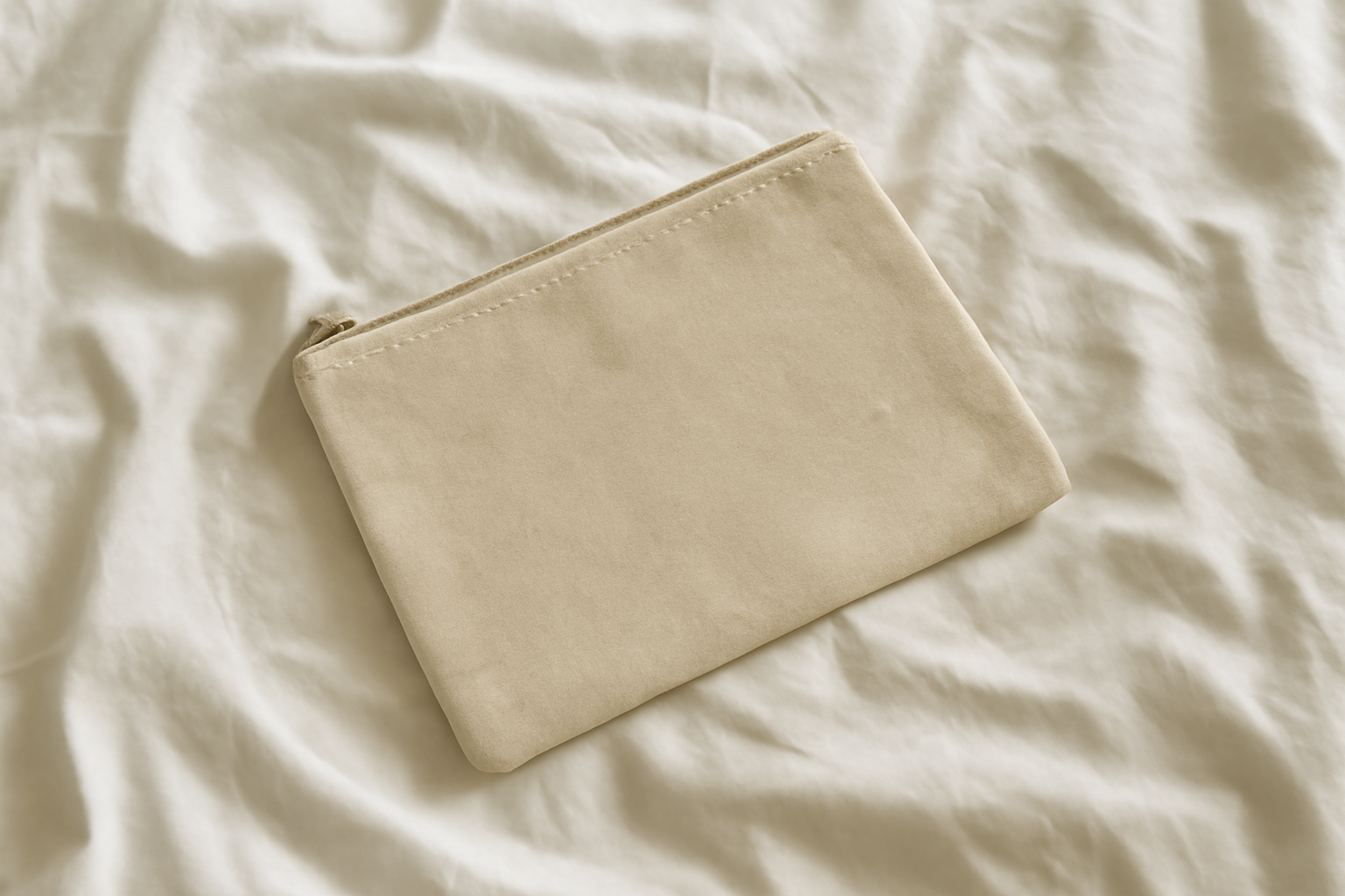 pochette en toile posée sur un lit clair