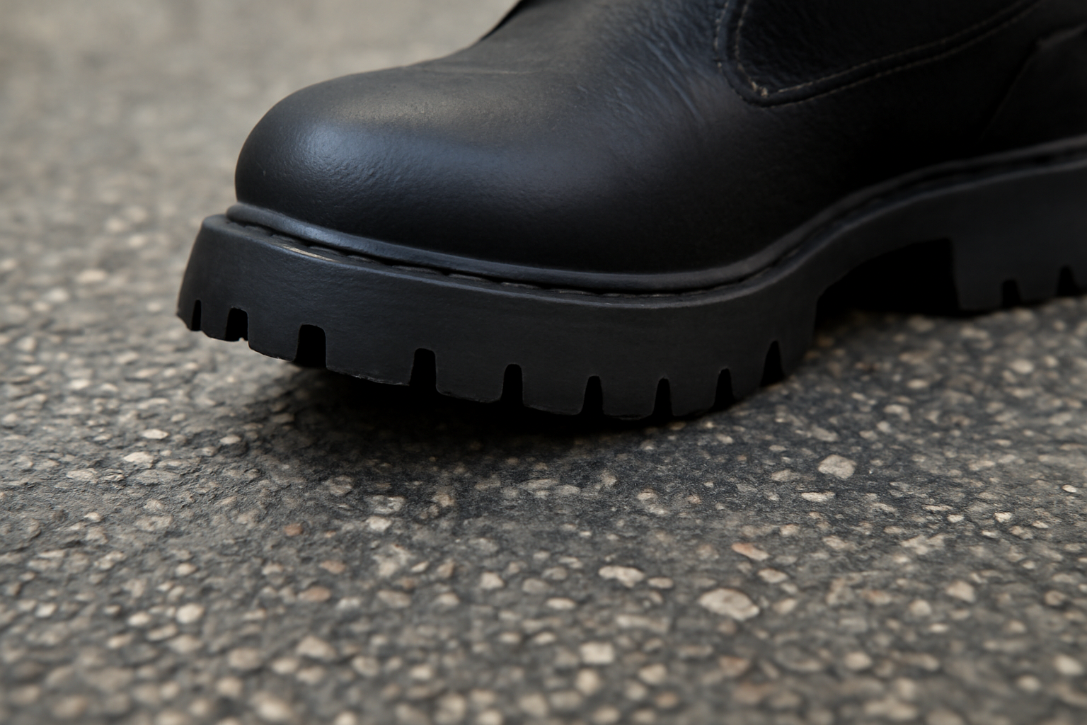 semelle crantée frottant un trottoir goudronné
